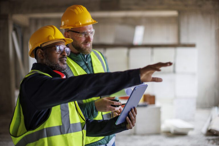 Two construction workers preparing for inspection