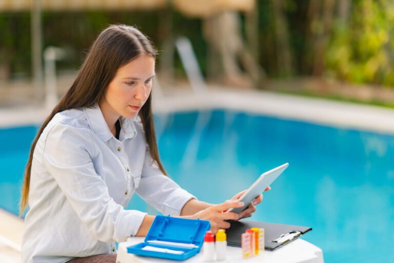 A pool inspector uses a tablet during a commercial pool inspection.