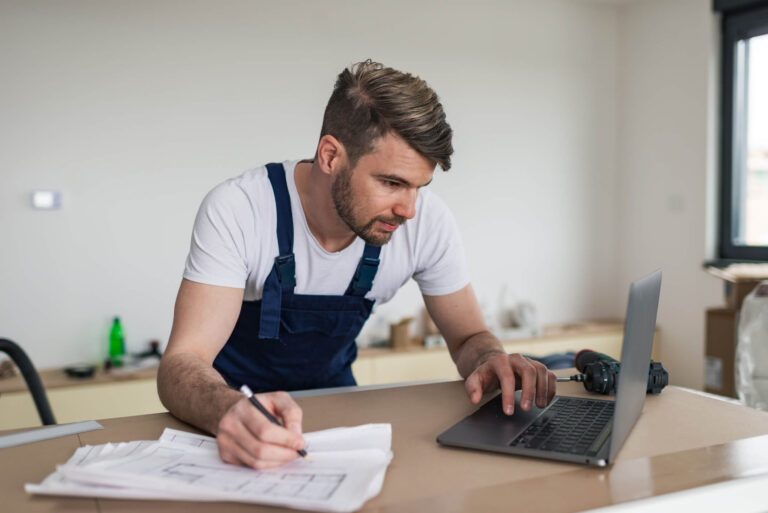 Contractor reviewing Miami-Dade building permit requirements on a laptop at a job site
